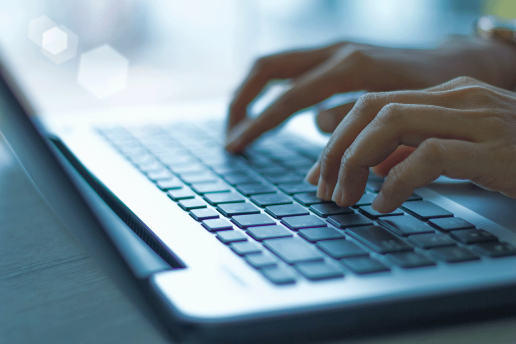 hands typing on a laptop keyboard