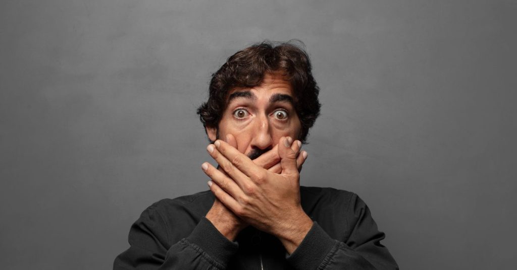 Man wit hands over mouth