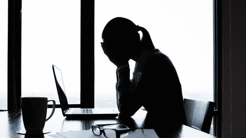 Woman stressed at work, contemplating AI and technology issues.